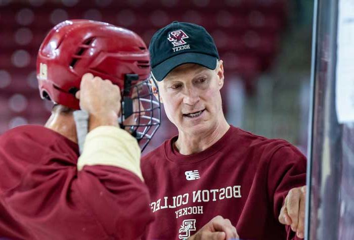 Coach Greg Brown coaching on ice with players.